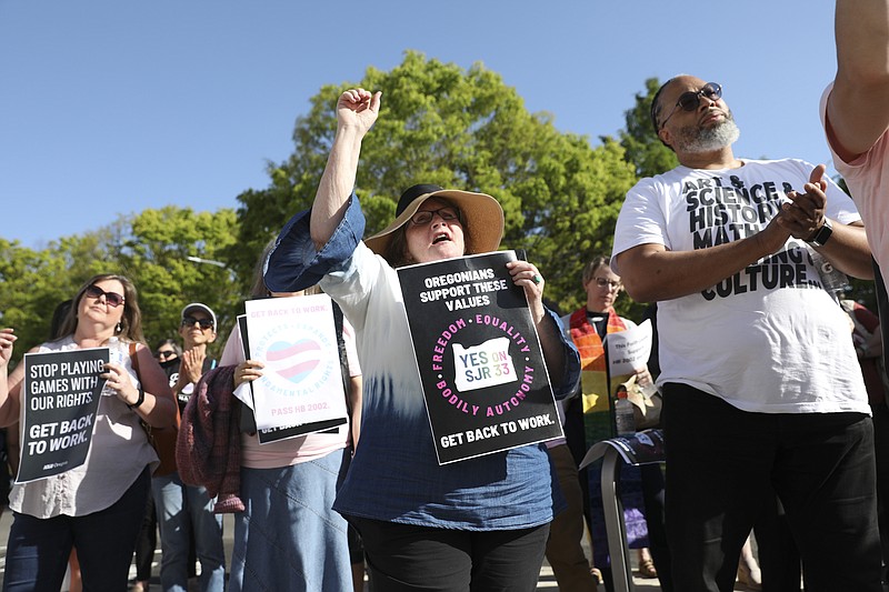 Carol Jarrett, of Salem, raises her fist during a rally calling for an end to the Senate Republican walkout at the Oregon State Capitol in Salem, Ore., Thursday, May 11, 2023. (AP Photo/Amanda Loman)