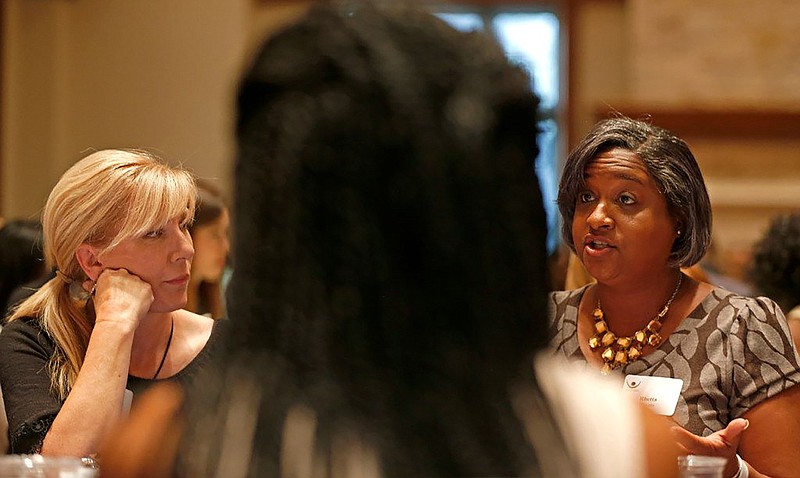 Rachel Ridge, left, watches Rhetta Bowers talk about race at the dining table during the Together We Dine event. A bill carried by Bowers (D-Garland) prohibiting racial discrimination on hairstyle or hair texture based on race advanced in the Texas House. (Jae S. Lee/The Dallas Morning News/TNS)