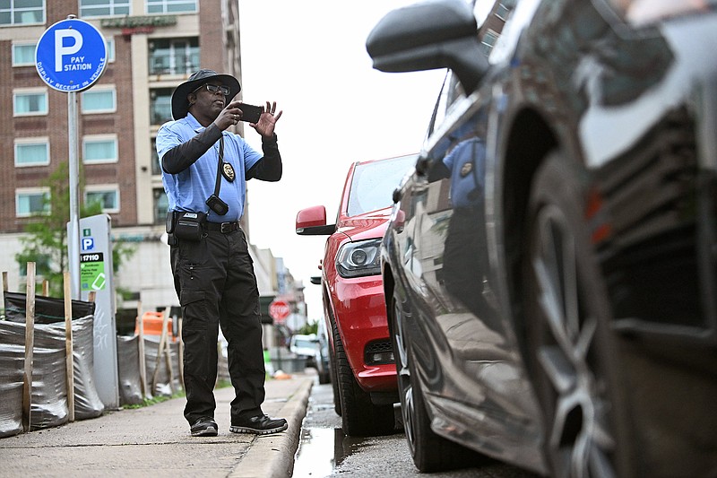 Keith Jordan, a parking enforcement technician, checks cars parked along President Clinton Avenue on Friday in downtown Little Rock.
(Arkansas Democrat-Gazette/Staci Vandagriff)