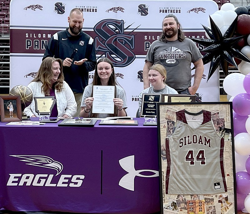 Graham Thomas/Herald-Leader
Siloam Springs senior Brooke Ross (seated, center) holds up a letter of intent to play basketball at the University of the Ozarks in Clarksville during a signing ceremony Monday at Siloam Springs High School. Also pictured are mother Jodina Ross, sister Natalie Ross (seated, right); (back from left) Siloam Springs head coach Beau Tillery and father Mark Ross.