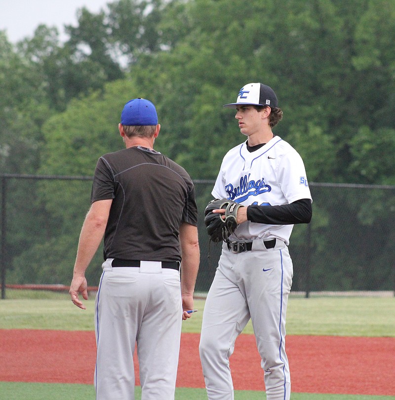 South Callaway coach Heath Lepper talks to starting pitcher Ryan Lepper in the Bulldogs' Class 3 District 7 tournament semifinal against rival North Callaway Monday at south Callaway's baseball field in Mokane. (Mexico Ledger/Jeremy Jacob)