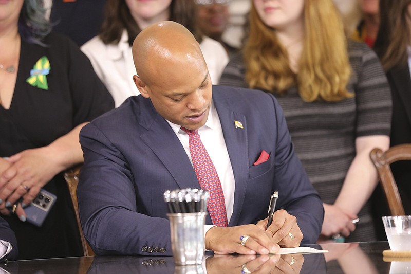 Maryland Gov. Wes Moore signs one of several gun-control measures during a bill-signing ceremony on Tuesday, May 16, 2023, in Annapolis, Md. One of the bills signed by the governor generally prohibits a person from wearing, carrying or transporting a gun into areas like schools or health care facilities. (AP Photo/Brian Witte)