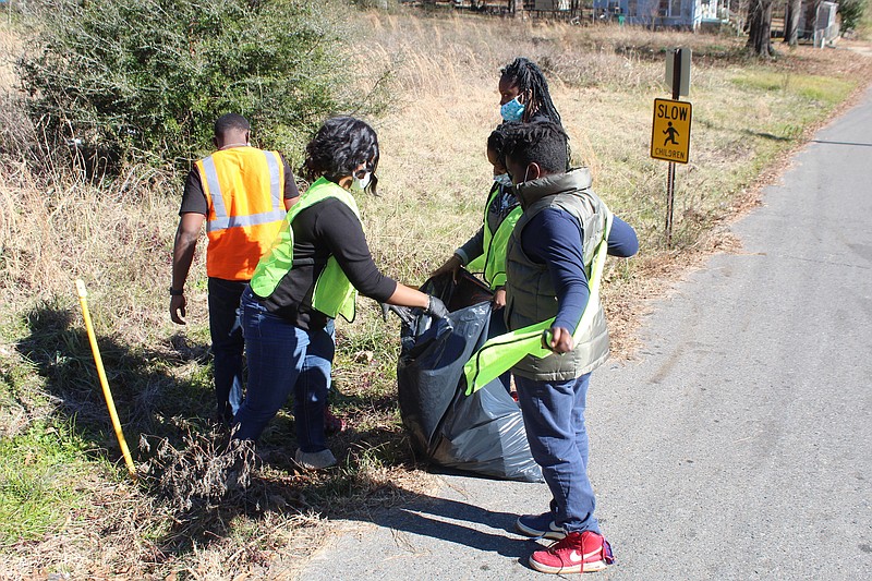 Local residents clean up a neighborhood in this News-Times file photo. Ward cleanups through Keep El Dorado Beautiful have been put on pause until the fall; Wards 1 and 3 held cleanups earlier this year.