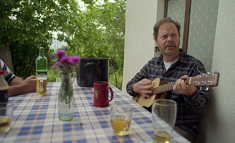 Rainn Wilson picks a guitarin a scene from "Rainn Wilson and the Geography of Bliss" on the Peacock streaming service.
(Peacock via AP)