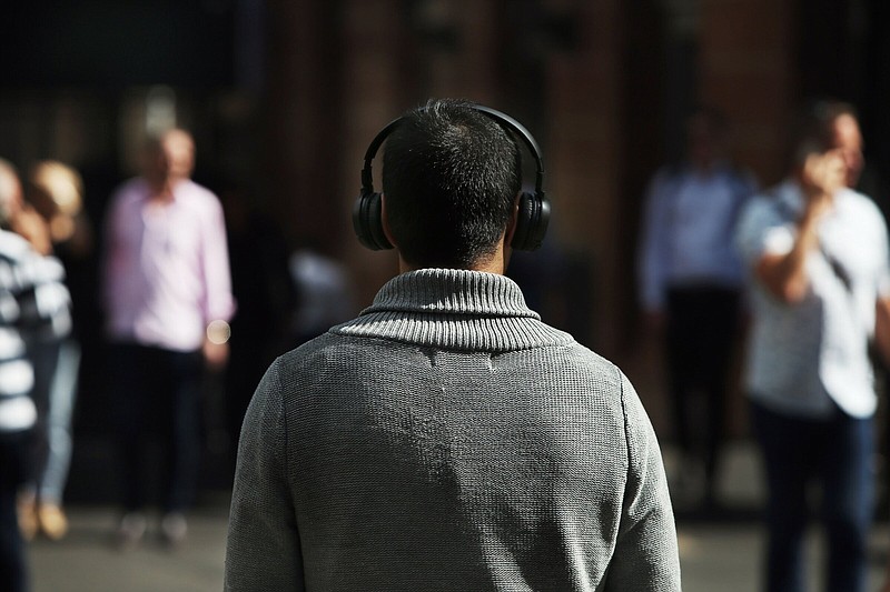 A pedestrian uses a headphone in the central business district in Sydney, Australia, on Friday, April 30, 2021. The government has tamed the virus by shuttering the international border and through rigorous testing and contact tracing, giving Australians an enviable level of freedom. But after winning the containment battle, the country now risks losing the vaccination war as supply shortages and a slow rollout jeopardize the economic recovery. MUST CREDIT: Bloomberg photo by Lisa Maree Williams