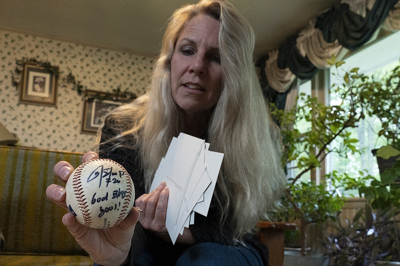 TeriAnn Reynolds sostiene una pelota autografiada por el pelotero colombiano Donovan Solano, el jueves 27 de abril de 2023, en Johnson City, Tennessee  (AP Foto/George Walker IV)