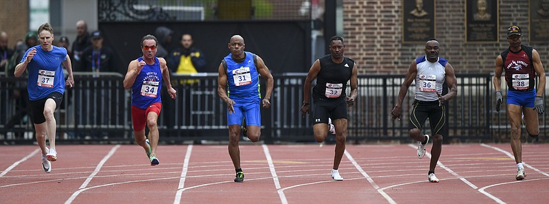 Competitors take off from the starting line in the masters men's 100-meter dash for age 60 and over. Members of the Shore A.C. team hold the winning baton after their victory in the women's 4x100-meter relay race for age 40 and over.  Washington Post photo by Jonathan Newton.