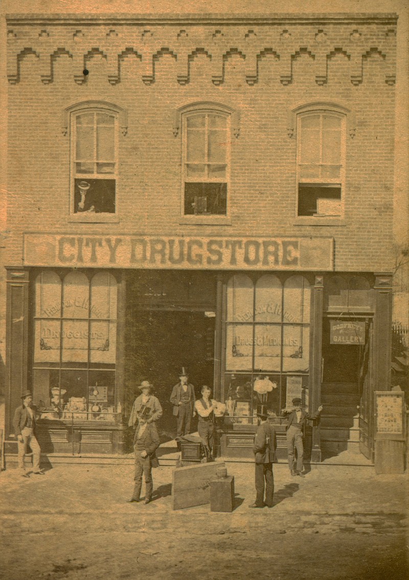 Photo courtesy the Kingdom of Callaway Historical Society
Herndon & Harris "City Drug Store," 2nd building from NW corner of 5th on Court Street. Godfrey's Gallery was above the drug store. Peter Godfrey is believed to be to the left of the camera, facing forward and wearing a top hat.