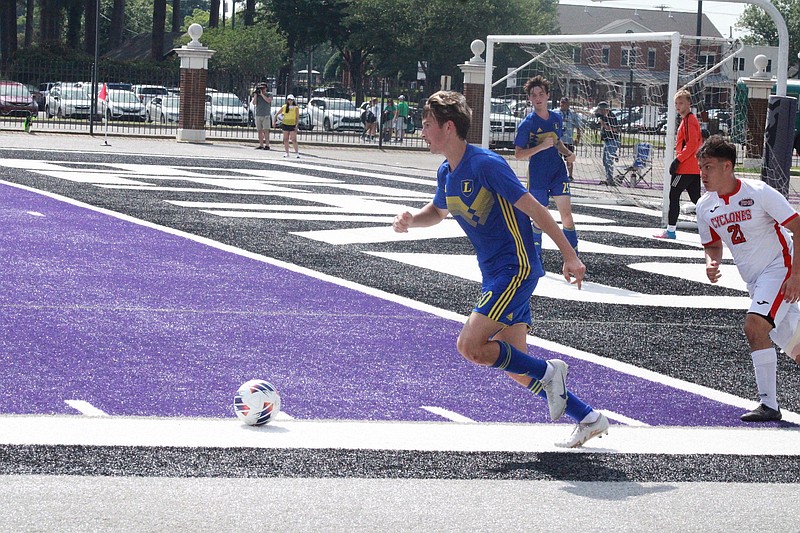 Lakeside's Caleb Rush dribbles away from Russellville's Abisai Martinez (21) Friday during the Class 5A state championship game at Estes Stadium in Conway. - Photo by Lance Porter of The Sentinel-Record