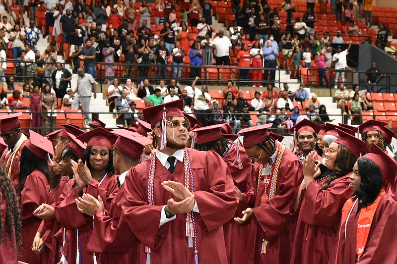 Graduates receive a rousing applause as they take their seats for graduation inside the Pine Bluff Convention Center arena. (Pine Bluff Commercial/I.C. Murrell)