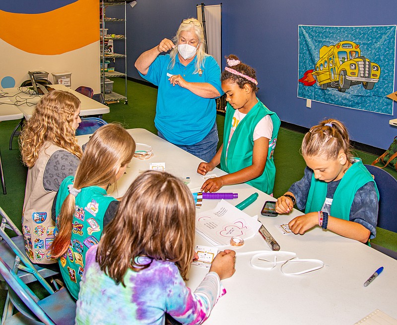 Annette Alberts with Lab Space Robotics teaches a group of Girl Scouts about basic electricity and electronics Saturday as they prepare to make their own LED circuits.  (Ken Barnes/News Tribune)