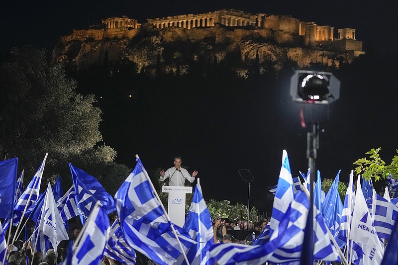 Supporters wave Greek flags as Greece's Prime Minister and New Democracy leader Kyriakos Mitsotakis gestures during his main election campaign rally in Athens, in front of the ancient Acropolis hill, on Friday May 19, 2023. Greece holds general elections on May 21. (AP Photo/Thanassis Stavrakis)