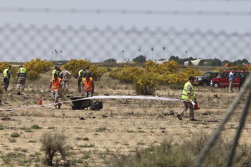 Emergency service members work in the area where an F-18 fighter jet crashed in Zaragoza, Spain, Saturday, May 20, 2023. An F-18 fighter jet crashed at an airbase in the Spanish city of Zaragoza but the pilot ejected successfully, the Spanish defense ministry said Saturday. The aircraft landed within the perimeter of the base, the defense ministry said on Twitter. (Fabian Simon/Europa Press via AP)
