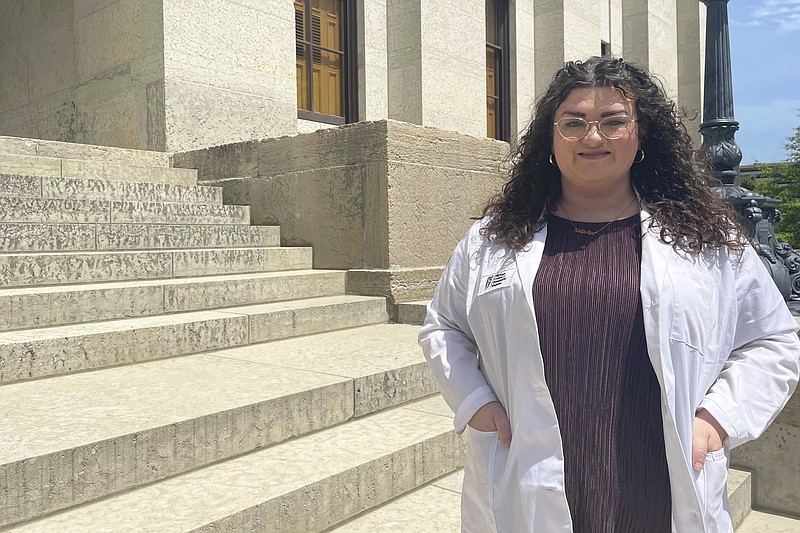 Alexandra Fountaine, a medical student at Ohio University, poses for a picture in front of the Ohio Statehouse in Columbus, Ohio, Thursday, May 11, 2023. Fountaine testified before a committee earlier this month advocating for a bill that would ban pelvic exams on unconscious patients without their express consent. (AP Photo/Samantha Hendrickson)