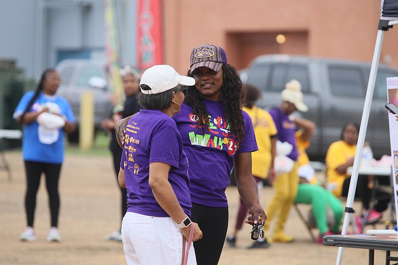 Marie Ferdinand-Harris, co-founder of the Be Like CJ Foundation, speaks with a supporter Saturday during the foundations Walk of Love in downtown Texarkana, Ark. The Be Like CJ Foundation was formed to continue the legacy of Ferdinand-Harris son, Cedrick “CJ” Harris Jr. CJ died after a tragic accident in 2021. The groups goal is to share the importance of living a loving life with students. (Staff photo by Danielle Dupree)