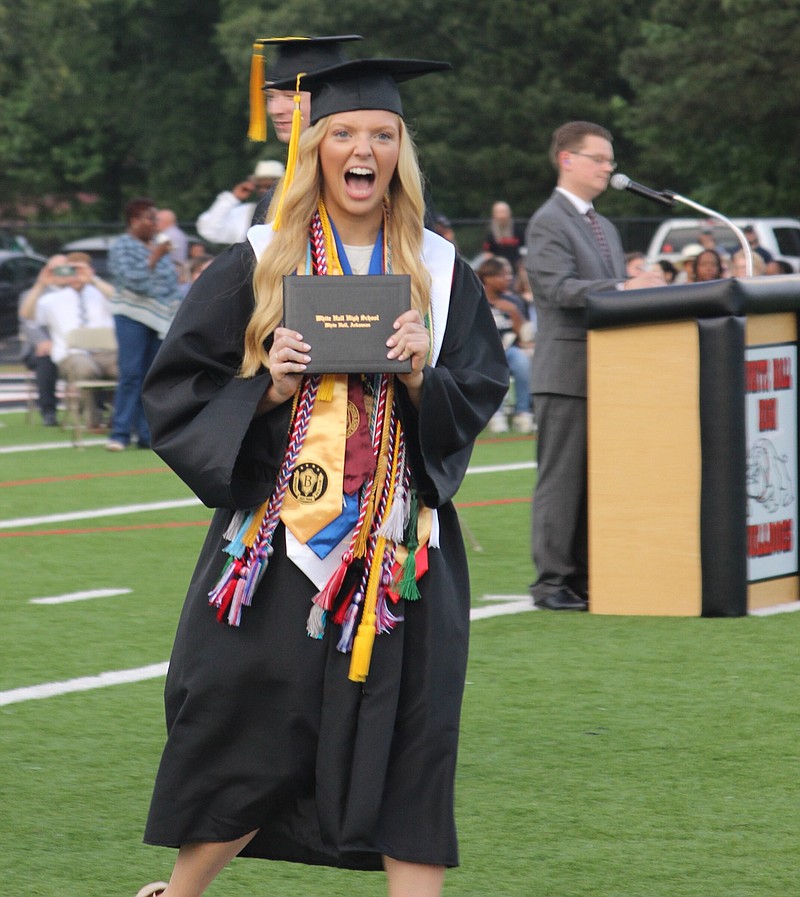 Honor graduate Reese Owens lets out a yell after she receives her diploma during White Hall High School's graduation Friday night at Bulldog Stadium. See inside for a photo page on the graduation. (Special to The Commercial/Deborah Horn)