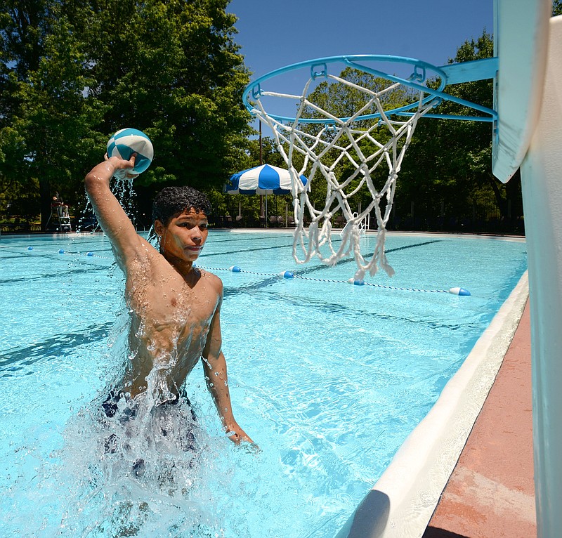 Christian Rock of Fayetteville leaps out of the water Saturday, May 29, 2021, to dunk a basketball while swimming on the first day of the season at Wilson Park Pool in Fayetteville. The pool opens for open swim from 1 to 4:30 p.m. Monday through Friday and 1 to 6 p.m. Saturday and Sunday. The pool is open for adult lap swimming from 10 a.m. to 1 p.m. Monday through Friday and noon to 1 p.m. Saturday and Sunday. Visit nwaonline.com/210530Daily/ for today's photo gallery.
(NWA Democrat-Gazette/Andy Shupe)