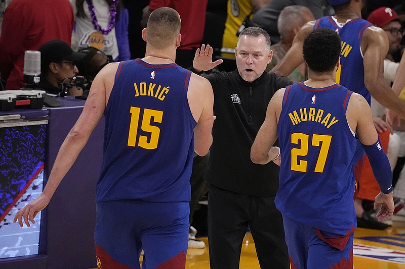 Denver Nuggets head coach Michael Malone, center, shakes hands with Denver Nuggets center Nikola Jokic (15) and guard Jamal Murray (27) in the second half of Game 3 of the NBA basketball Western Conference Final series against the Los Angeles Lakers Saturday, May 20, 2023, in Los Angeles. (AP Photo/Mark J. Terrill)