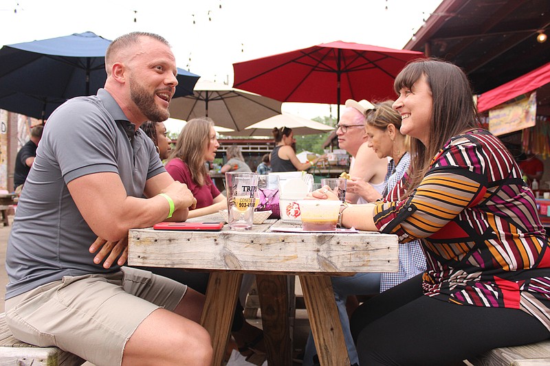 Jacki Davis, right, of Texarkana, and friend Mark, of Shreveport, enjoy a conversation during Taco Fest at Redbone Magic Brewing on Sunday afternoon, May 21, 2023, in Texarkana, Texas. The festival, the brainchild of Redbone founder Roger Sheppard, was held to showcase local businesses — in this case, taco vendors. (Staff photo by Stevon Gamble)