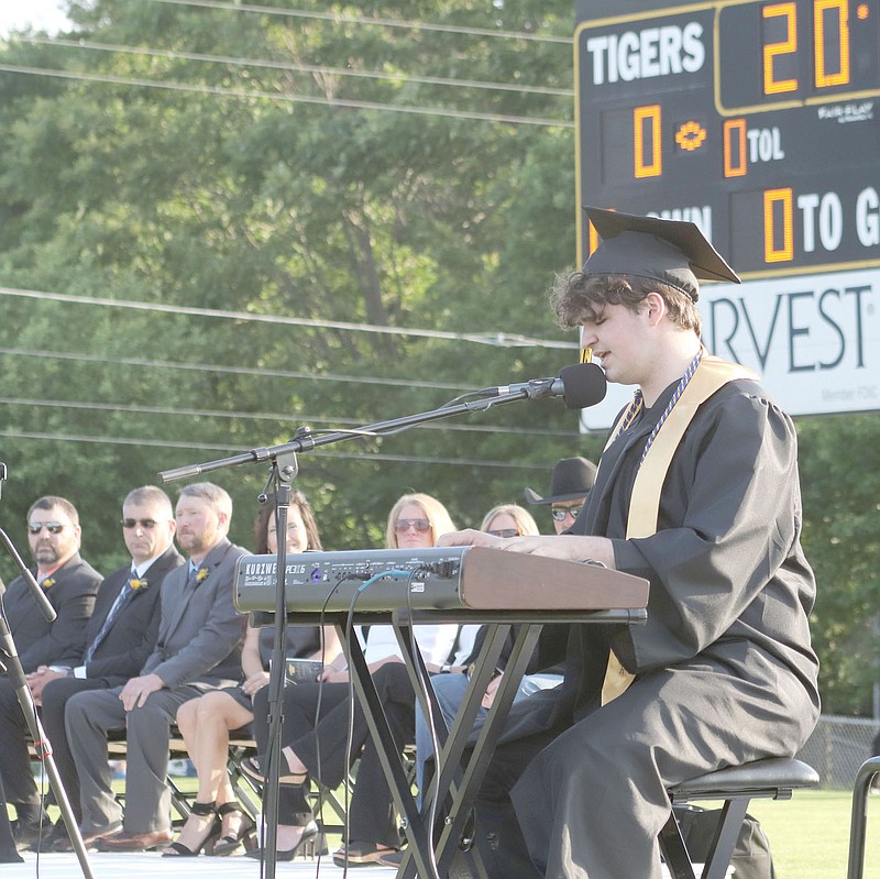 Prairie Grove senior Amery Phillips plays keyboard and sings "Godspeed" during the graduation ceremony.