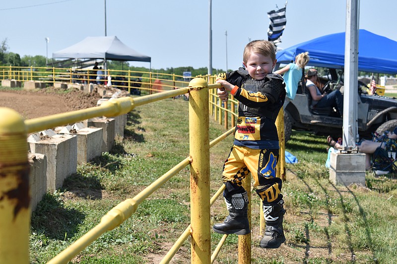 Democrat photo/Garrett Fuller — Emmitt Dilse, 4, of Jamestown, stands on a fence Saturday as he awaits the beginning of the Russellville Lions Club ATV rodeo. He was one of the youngest to compete in the event, which hosted riders of all ages.