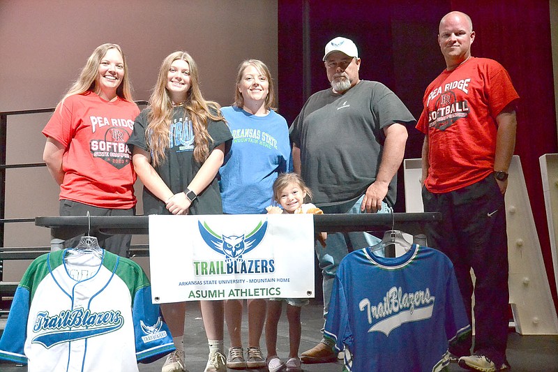 Annette Beard/Pea Ridge TIMES
Lady Blackhawk softball seniors Ashley Early signed a letter of intent to continue softball in college. Early, daughter of Brian and Christie Earley, plans to play softball for Arkansas State University of Mountain Home. Blackhawk assistant coach Elzie Yoder, left, and head coach Joshua Reynolds, right, joined Earley and her family in the celebration.