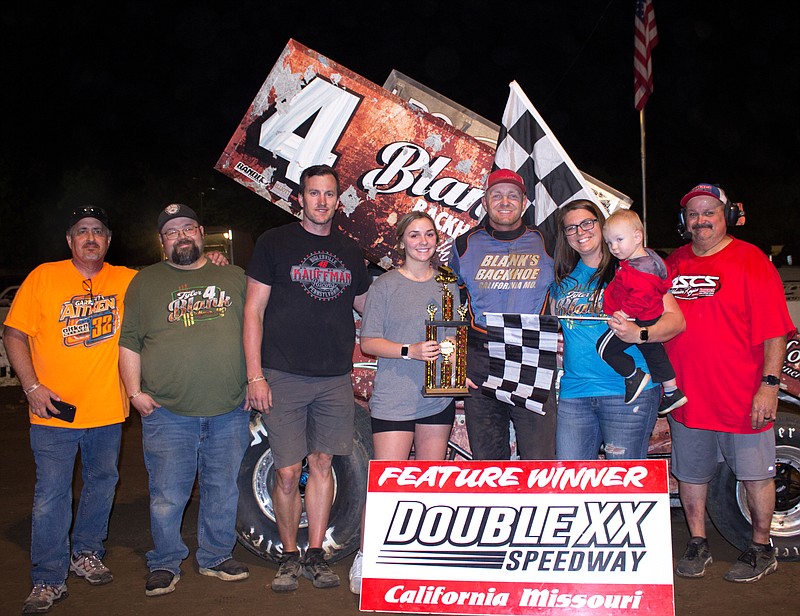 Submitted/ Courtesy of Carol Wirts 
Tyler Blank, of California, claims his first Double X 360 winged sprint feature win of the season.  He is pictured with his wife, Kelsey, and son, Maverick, as well as, from left, Rob Balga, David Burlingame, Aaron Chambers, trophy girl Daphne Wehmeyer, and Director of Competition Brad Steudle.