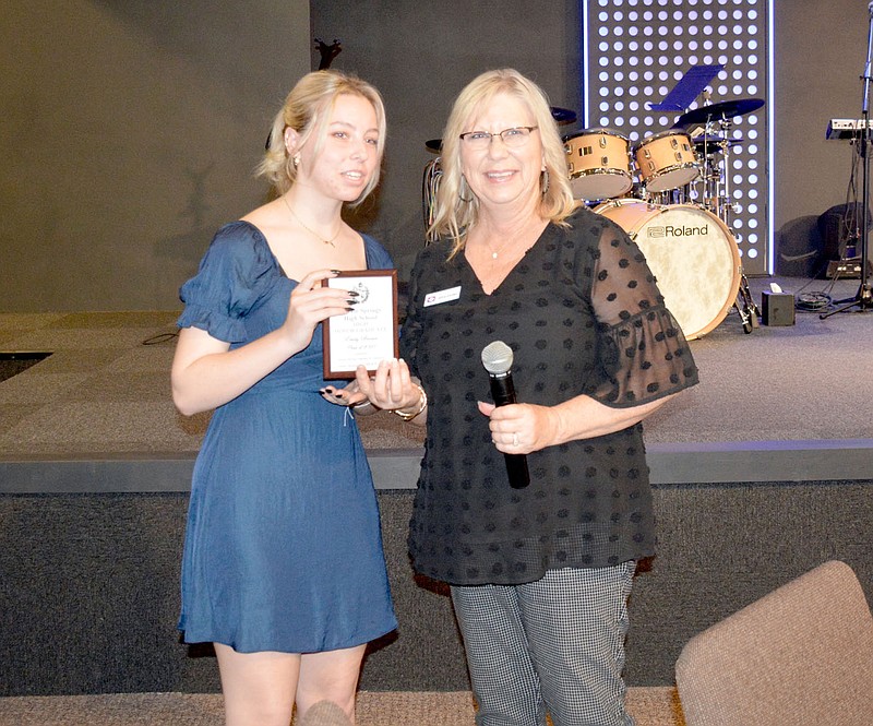 Marc Hayot/Herald-Leader Emily Brown (left) receives her plaque from Centennial Bank Manager Alice Corder at the Siloam Springs Chamber of Commerce's Honor Graduate Luncheon on Thursday at New Life Church.
