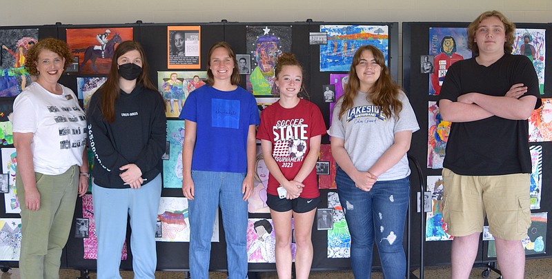 From left, Lakeside High School Art Teacher Katie Smith-Johnson and students Eli Jordan, Hazel Copeland, Mia Williams, Clara McCarley, and Elijah Adams are shown with their artworks inside the lobby of the high school welcome center on Monday. - Photo by Donald Cross of The Sentinel-Record