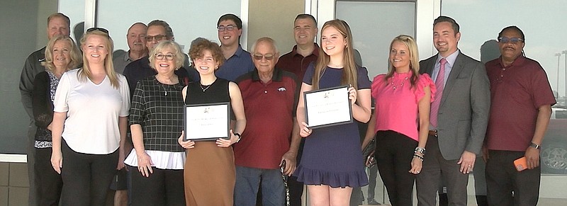 Scholarship recipients Anna Lewis, front, left, and Katherine Foreman, front, right, hold up their scholarship certificates as they stand with members of the Greater Hot Springs Kiwanis Club on Wednesday at Hibachi Sushi Buffet. - Photo by Lance Porter of The Sentinel-Record