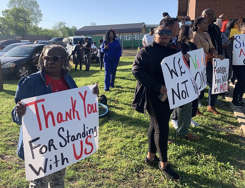 FILE - Glenda Austin of Idabel, Oklahoma, holds a sign with other protesters Monday April 17, 2023, outside the McCurtain County Commissioners meeting room. A number of McCurtain County residents were outraged by comments made by local officials on a recording and are asking for the resignation of the sheriff, two county commissioners and others. (Staff photo by Lori Dunn)