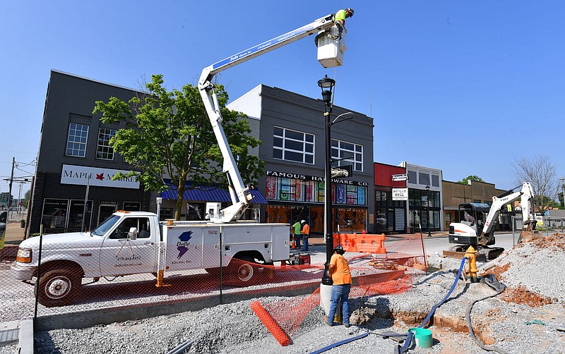 Steven Moore (top) and Augustine Lopez, both electricians with Dolle Electric in Rogers, install a street lamp Monday, May 22, 2023, along Emma Avenue in Springdale. The new lighting is part of a larger project to renovate the downtown and realign the Razorback Greenway that is slated to be completed this spring. Visit nwaonline.com/photo for today's photo gallery. 
(NWA Democrat-Gazette/Andy Shupe)