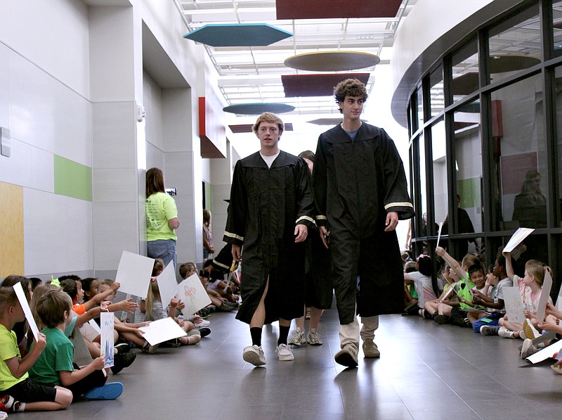 Pleasant Grove High School seniors Evan Damron, left, and Dawson Anderson lead the Senior Walk on Tuesday morning, May 23, 2023, at Margaret Fischer Davis Elementary School in Texarkana, Texas. Elementary students lined the hallway to greet the soon-to-be graduates with smiles, hugs and handmade congratulatory messages. The Class of 2023 as 207 students — the most in school history, high school Principal Kristen Giles said. (Staff photo by Stevon Gamble)