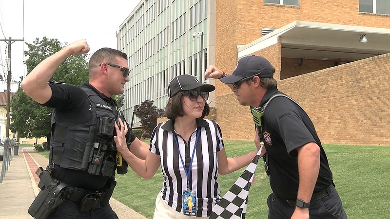 Visit Hot Springs Special Events Manager Alexis Hampo, center, works to keep the peace between Hot Springs police Sgt. Jarret Cantrell, left, and Hot Springs Fire Department driver Allen Goines while promoting the upcoming Stueart Pennington World Championship Running of the Tubs. - Photo by Lance Porter of The Sentinel-Record