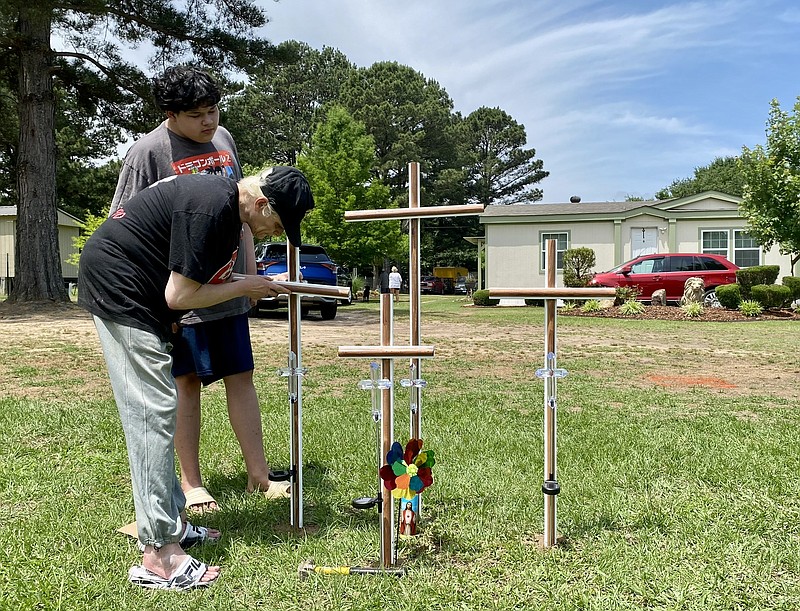 Charity Lopez and her son, Adrian Vargas, install crosses in the front yard of the house where the bodies of four members of the Olalde family were discovered Tuesday, May 23, 2023, on Lemon Acres in Nash, Texas. Caesar Olalde, 18, who reportedly had barricaded himself in the house, surrendered to police and was arrested at the scene. The teenager is charged with capital murder of multiple persons. His relationship to the victims has not been disclosed. (Staff photo by Stevon Gamble)