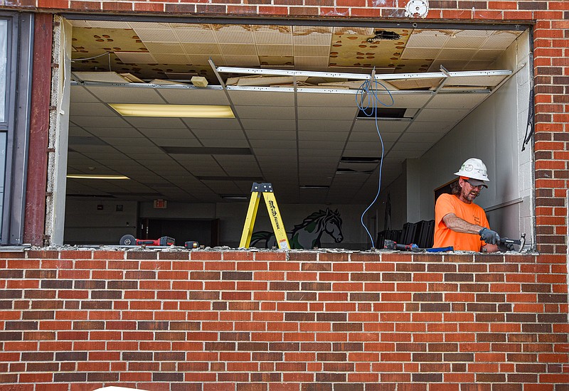 Julie Smith/News Tribune photo: 
Chris Doyle of Central MIssouri Glass in Boonville knocks out remaining material following the removal of a large window from the cafeteria at Thorpe Gordon School, which is undergoing a major renovation over the summer. Doyle and a crew had removed numerous old windows and installed new ones by Wednesday. In addition to new windows, the school will have installed new air conditioning and heating units, removing the baseboard heaters that were installed when the building was constructed in 1956.