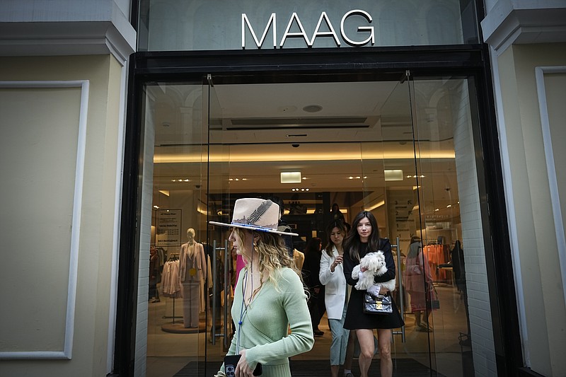 FILE - A woman exits a newly opened Maag store, a former Zara flagship store, in Moscow, Russia, Thursday, April 27, 2023. When Russia invaded Ukraine, companies were quick to respond, some announcing they would get out of Russia immediately, others vowed to curtail sales and new investment. More than a year later, its clear: Leaving Russia isn't as easy as the first announcements might have made it seem. (AP Photo/Alexander Zemlianichenko, File)