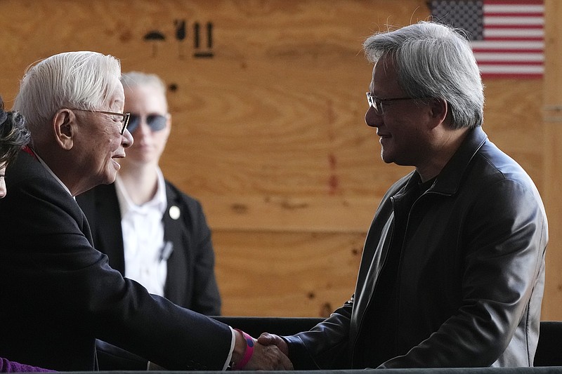 File - Taiwan Semiconductor Manufacturing Company founder Morris Chang, left, shakes hands with Nvidia Co-founder, President, and CEO Jensen Huang, right, at the TSMC facility under construction in Phoenix, Tuesday, Dec. 6, 2022. Nvidia shares skyrocketed early Thursday after the chipmaker forecast a huge jump in revenue for the next quarter, notably pointing to chip demand for AI-related products and services.(AP Photo/Ross D. Franklin, File)