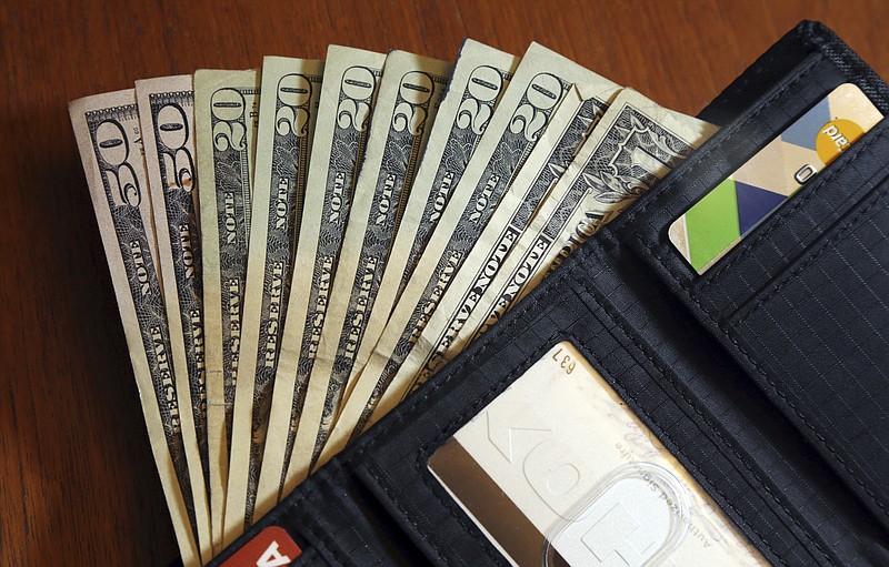 FILE - In this June 15, 2018, file photo, cash is fanned out from a wallet in North Andover, Mass. As more states adopt pay transparency laws, many small businesses will need to comply with legislation if they or the candidates they&#x2019;re sourcing are located within these states.  (AP Photo/Elise Amendola, File)