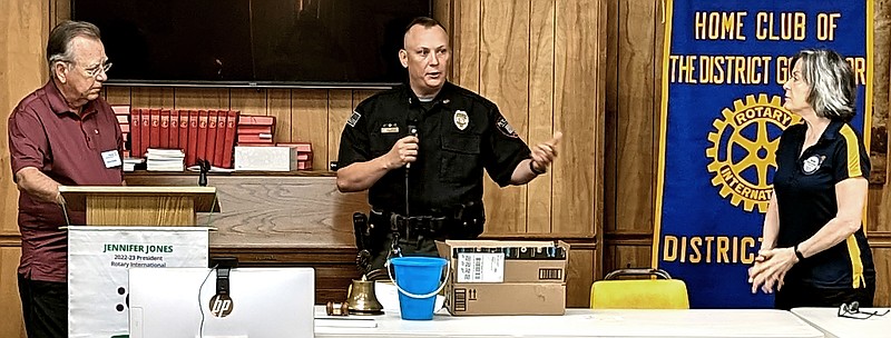 Drew Kahle, left, Hot Springs Village Rotary grants committee chair, and Melanie Pederson, right, grants committee member, present items for the Mountain Pine Police Department to its Police Chief Joshua Jester at their meeting Thursday. - Submitted photo