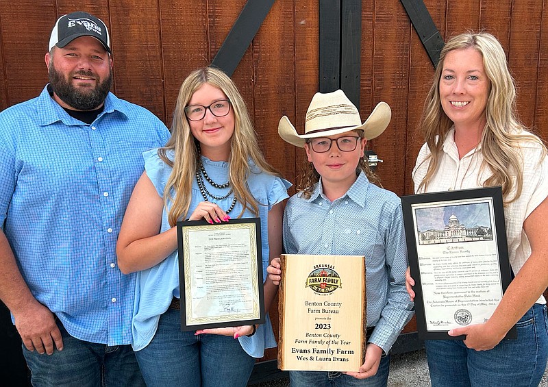 Wes Evans, daughter Emma, 14, son Weston, 11, and wife Laura show the awards they received on Friday at Evans Cattle Company in rural Highfill during ceremonies honoring them as the 2023 Benton County Farm Family of the Year. Randy Moll/Westside Eagle Observer