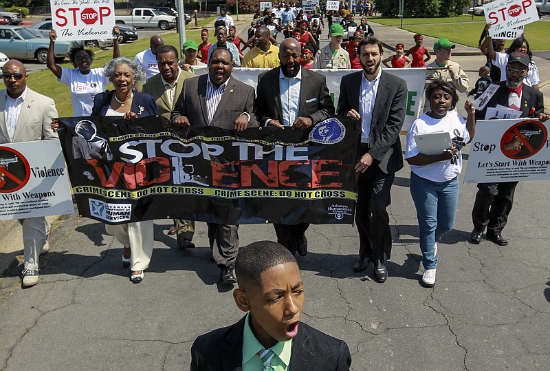 Kaylen Smith (bottom) a youth commissioner with the Arkansas Martin Luther King Jr Commission, is shown leading a peace march during a Stop the Violence Youth Summit held in 2014 in Pine Bluff. Because of Pine Bluff's homicides, especially those involving youth, another nonviolence rally is being planned for September. (Arkansas Democrat-Gazette file photo/Benjamin Krain)