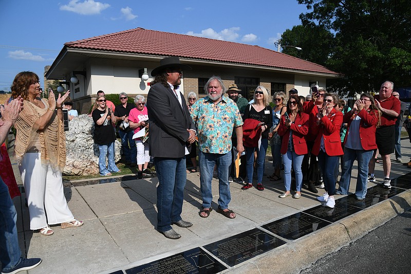 Buddy Jewell is cheered on in front of his plaque with Arkansas Walk of Fame founder and president, Tom Wilkins, on Friday. - Photo by Lance Brownfield of The Sentinel-Record