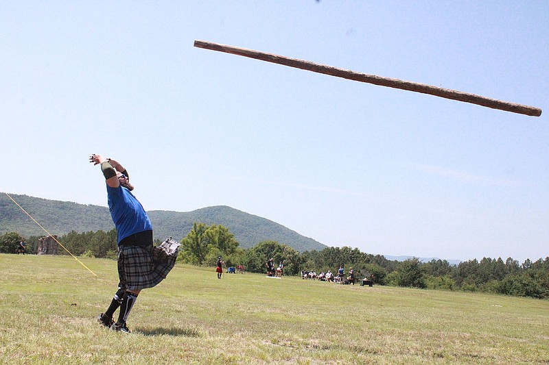 Brett Rector competes in the caber toss during the third annual Highland Games Saturday at Cedar Glades Park. - Photo by Lance Porter of The Sentinel-Record