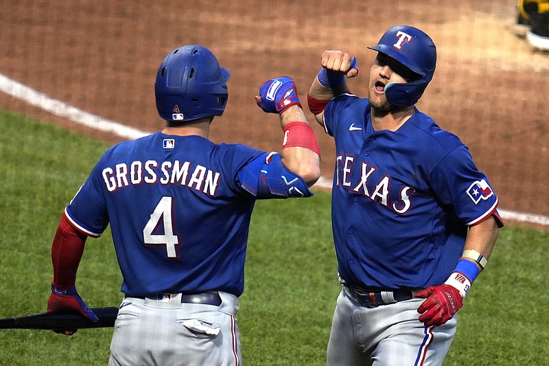 Texas Rangers' Josh Jung, right, celebrates with Robbie Grossman as he returns to the dugout after hitting a solo home run off Pittsburgh Pirates relief pitcher Duane Underwood Jr. during the eighth inning Tuesday, May 23, 2023, in Pittsburgh. (AP Photo/Gene J. Puskar)