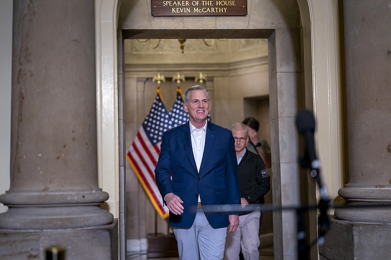 Speaker of the House Kevin McCarthy, R-Calif. — joined at right by his top negotiator on the debt limit, Rep. Patrick McHenry, R-N.C., chairman of the House Financial Services Committee — smiles as he arrives to talk to reporters at the Capitol on Sunday, May 28, 2023, in Washington. The mediators came to an "agreement in principle" with the White House that would avert a potentially disastrous U.S. default, but still has to pass both houses of Congress. (AP Photo/J. Scott Applewhite)