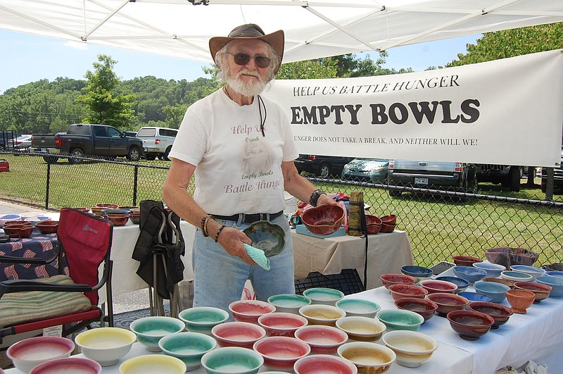Bennett Horne/The Weekly Vista Benton County Empty Bowls, a nonprofit organization working to fight hunger in northwest Arkansas and southwest Missouri, is one of the vendors at the Bella Vista Farmers and Makers Market this season. Phillip Calkins, pictured here at the group's booth on Sunday, helped start the organization in Benton County. He is currently seeking volunteers to take over his duties when he has to retire from "the efforts and work."