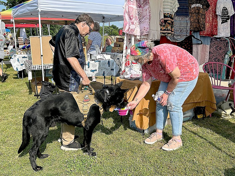 Lynn Kutter/Enterprise-Leader
Vendor Diana Milner gives a cup of water to Aries, a German Shepherd, at the Farmington Farmers Market on Saturday, May 27. Aries, owned by Carl Martin of Farmington, is being trained to be a therapy dog at Arkansas Children's Hospital in Springdale. Farmington Farmers Market is open 9 a.m. to 1 p.m. Saturdays through October.