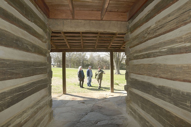 Mattison Griffin (right), interpreter at Prairie Grove Battlefield State Park, shows a dog-trot style log home in March during a tour of historic Civil War era homes at the park.
(NWA Democrat-Gazette/Flip Putthoff)