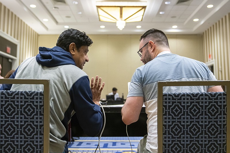 Mirle Shivashankar and Kevin Moch talk during a meeting of the word panel to finalize the 2023 Scripps National Spelling Bee words Sunday, May 28, 2023, at National Harbor in Oxon Hill, Md. (AP Photo/Nathan Howard)